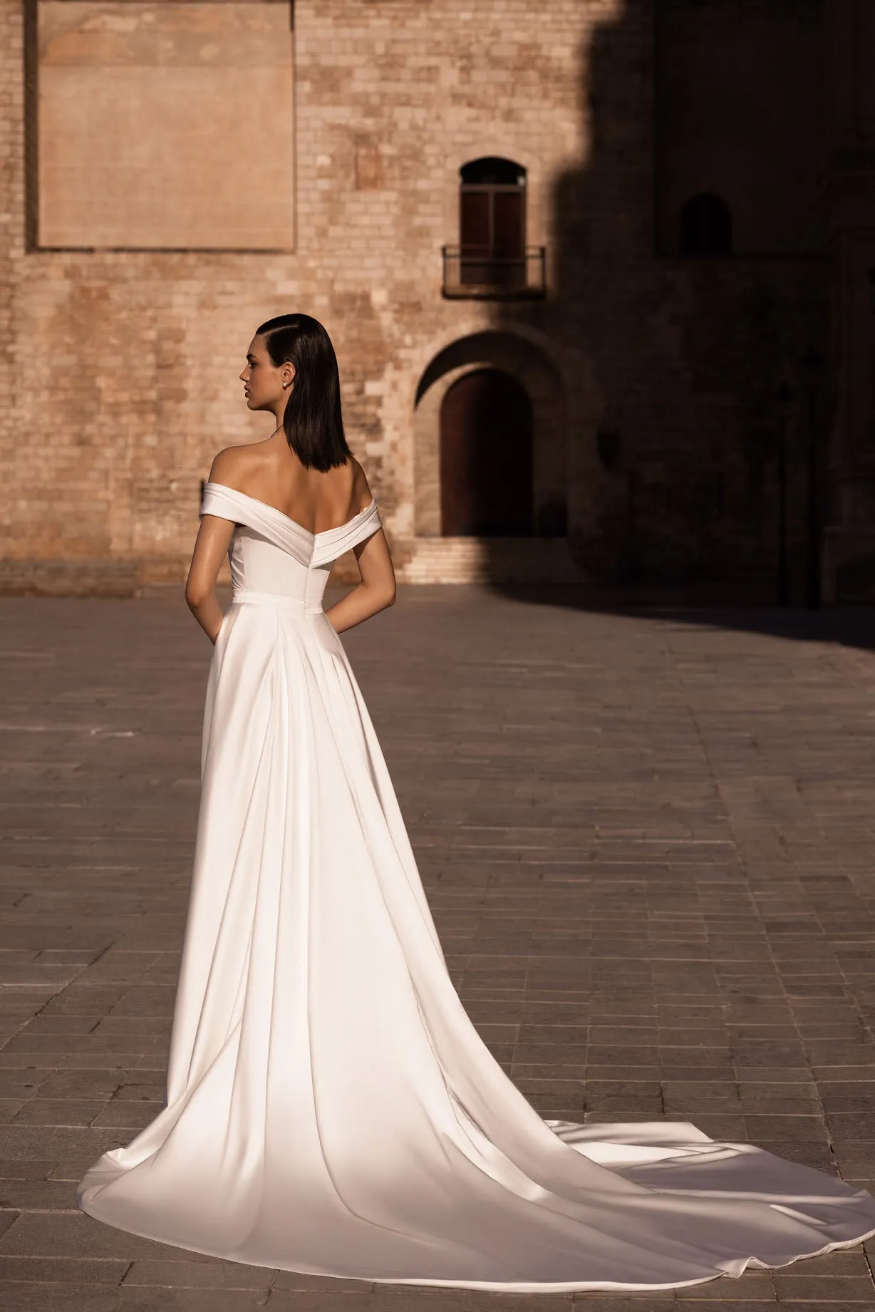 Introducing our stunning sheath wedding dress, an epitome of modern elegance and sophistication. Crafted from lustrous glossy fabric, it gracefully hugs your curves, exuding confidence and allure. - Image 2