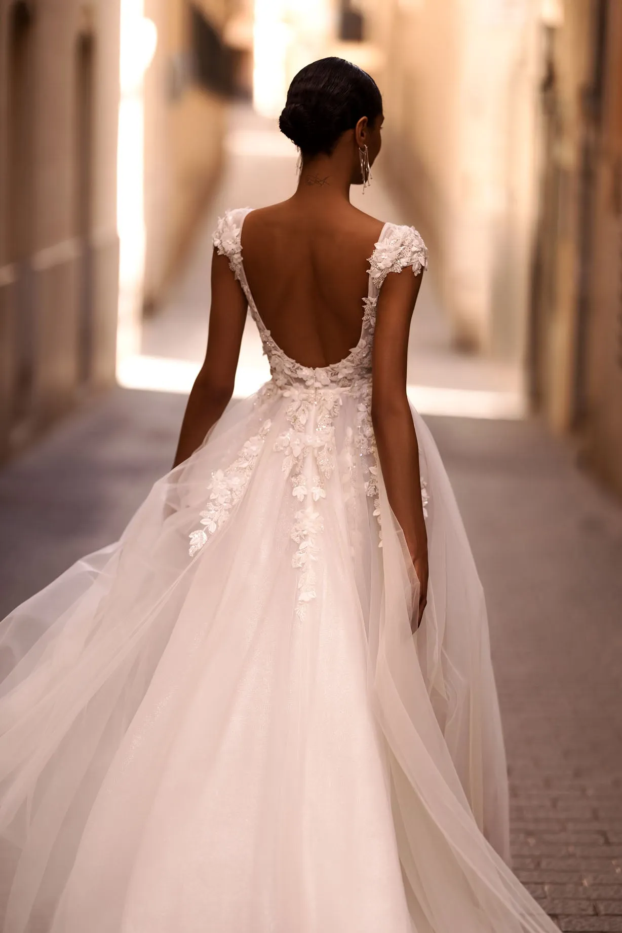 ntroducing our captivating A-line wedding dress, a vision of ethereal beauty and romance. Crafted from delicate tulle fabric, this dress exudes grace and femininity with every step. - Image 2