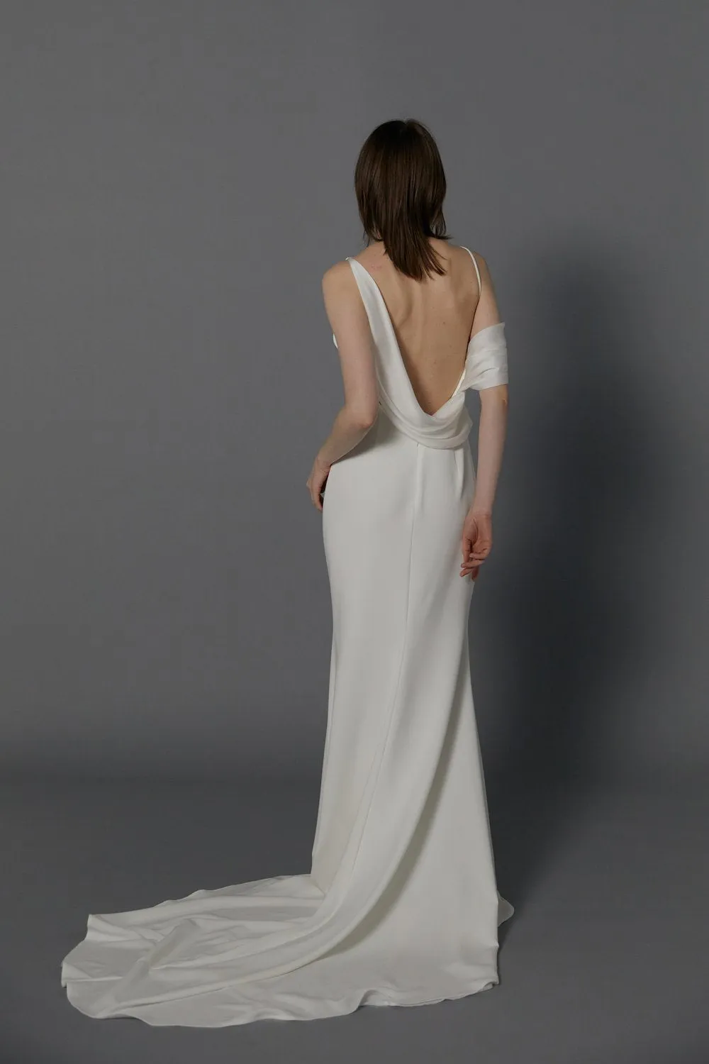 The draped off-shoulder asymmetrical neckline gives a modern take on a classic design wedding dress. - Image 2