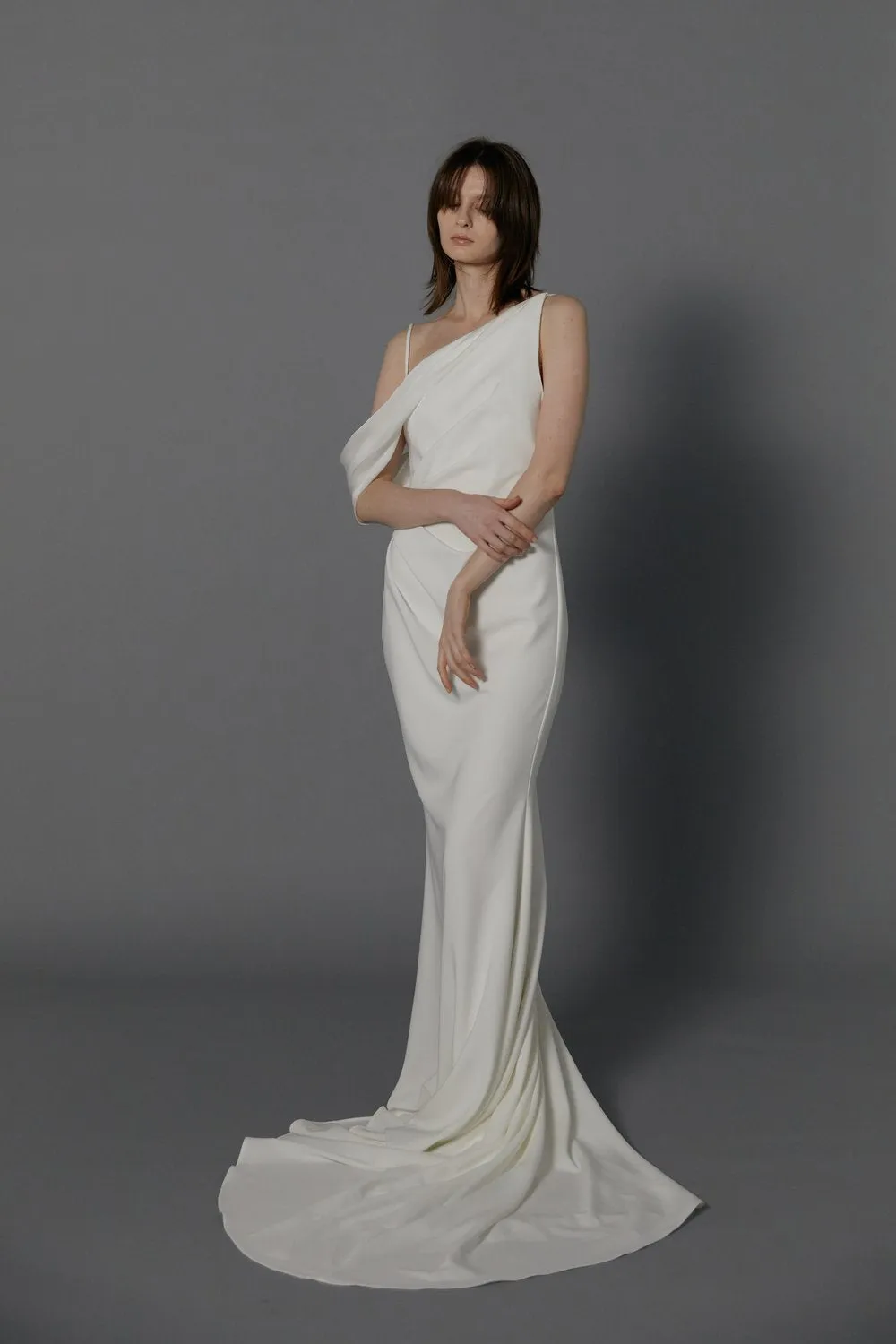 The draped off-shoulder asymmetrical neckline gives a modern take on a classic design wedding dress. - Image 4