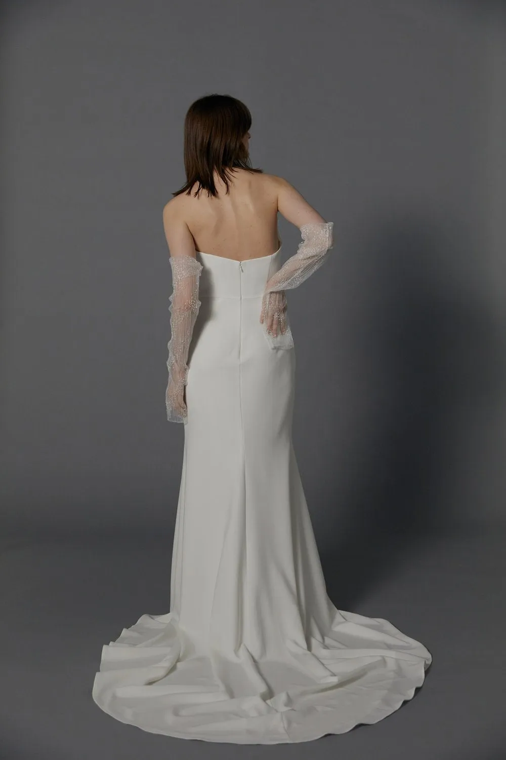The unique strapless neckline creates a breathtaking statement of regal grandeur highlighting a modern high slit. A celebration of romance, luxury, and modernity. - Image 2